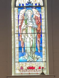 The First World War memorial window at the Nativity: an angel on clouds surmounting the caption "Death is swallowed up in victory" (1 Cor 15.54).