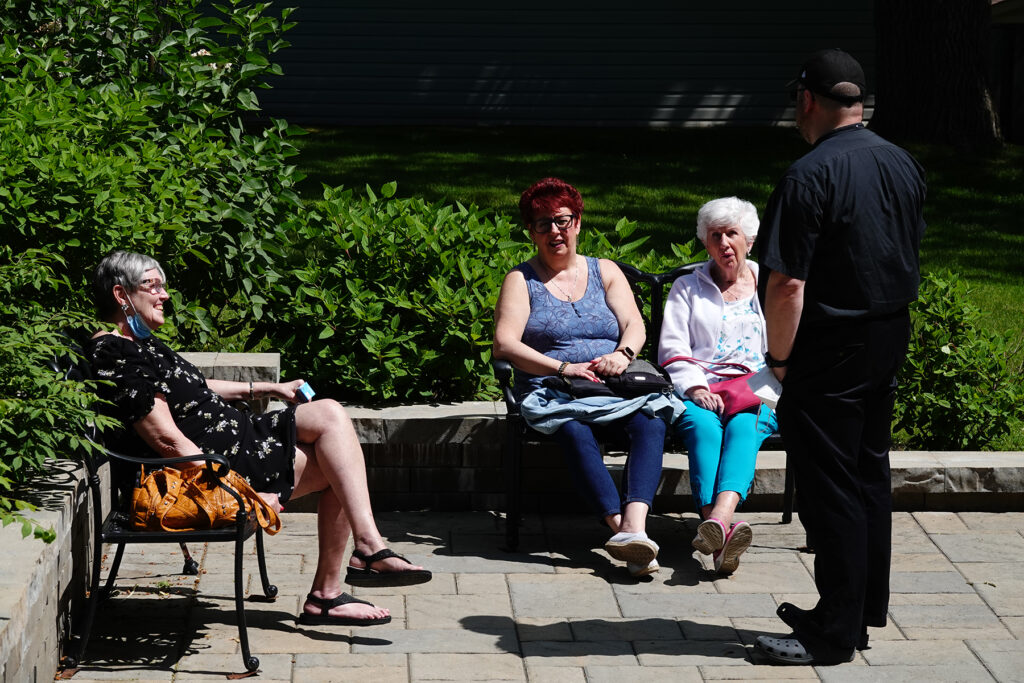 People gather in the Nativity Gardens at a recent outdoor coffee hour