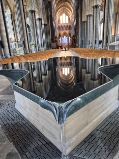 A photograph of the large font at Salisbury Cathedral. Cruciform in shape, water flows constantly from the four points--a reminder of the living water in which we are baptized.